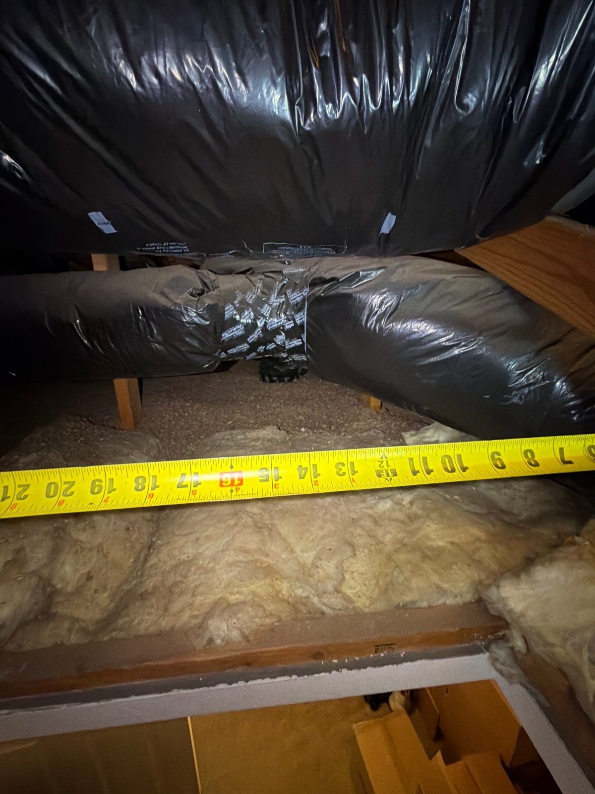 Tape measure laid across rafters and insulation