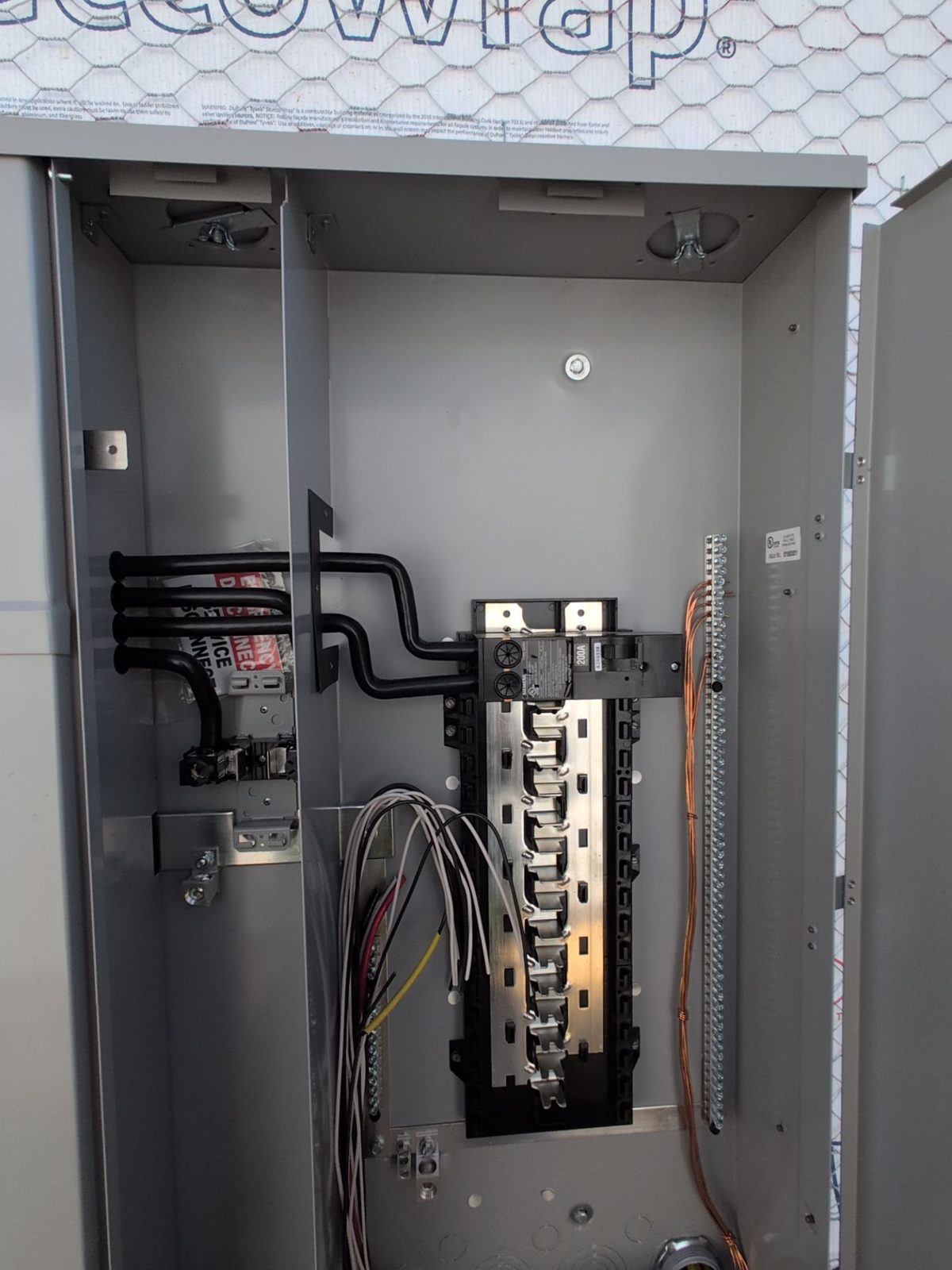 Residential main service panel with the cover off, showing the 200A main breaker and branch circuits