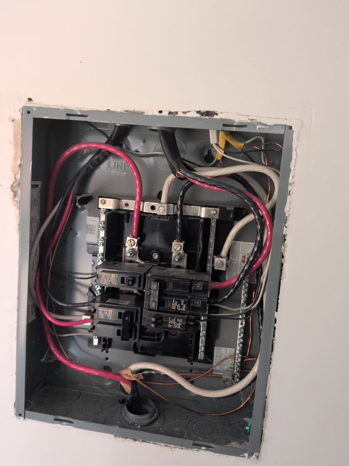 Open residential load center showing breakers and conductors